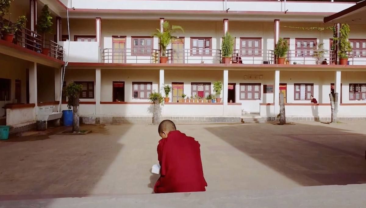 A monastery courtyard in India with monks' quarters and potted plants, supported by The Maitri Project