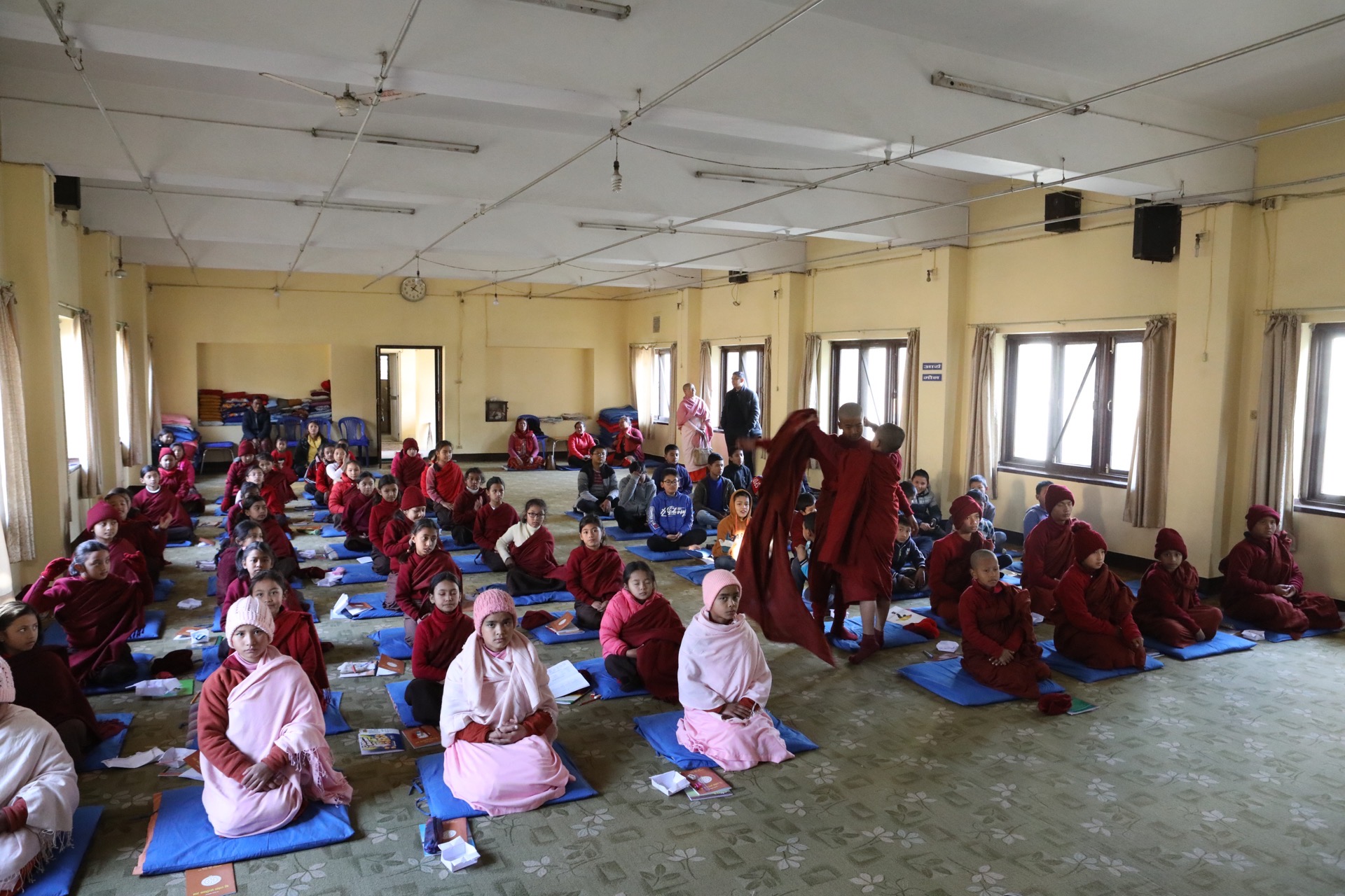 A community gathering with monastics in a hall