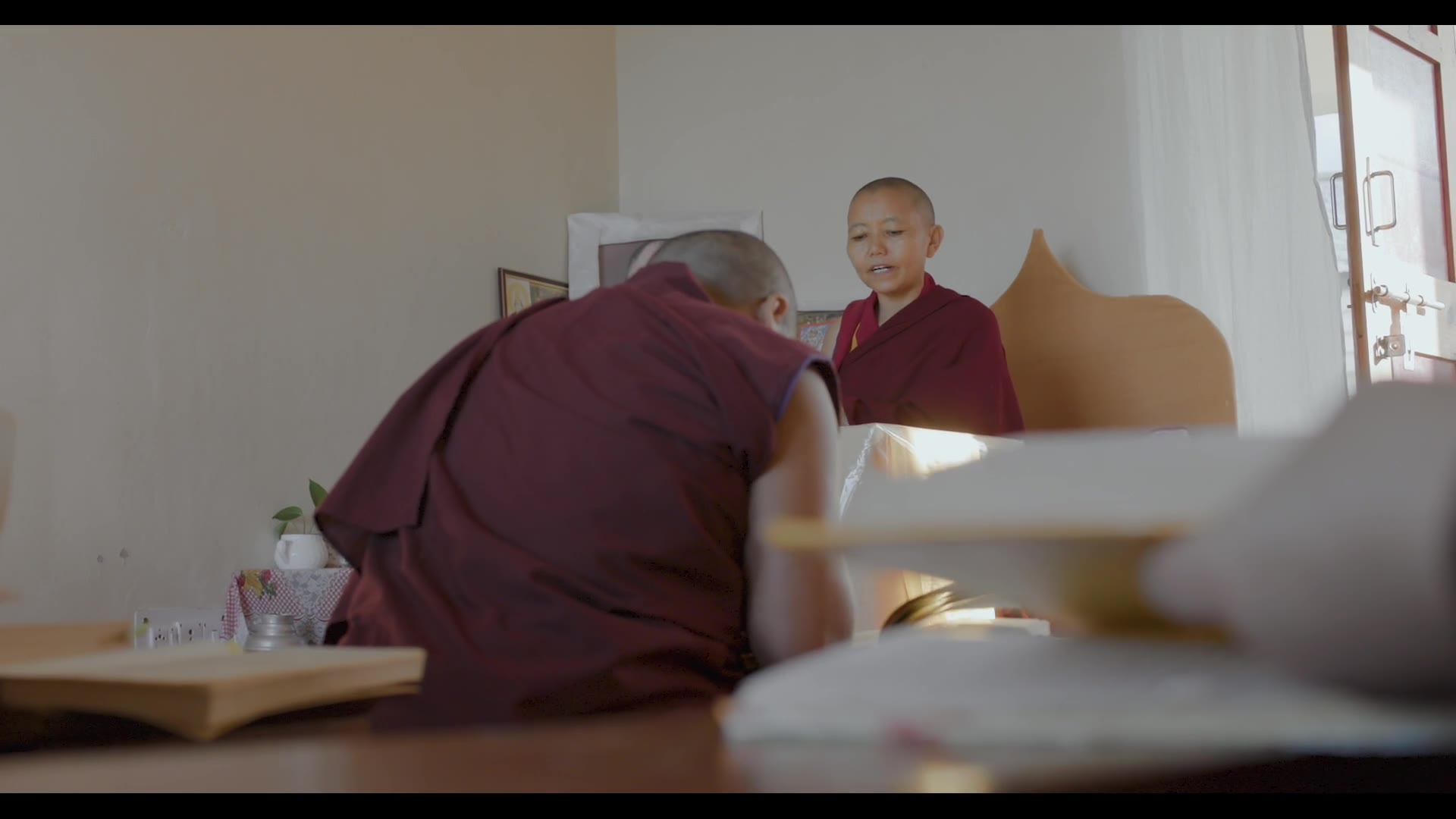 Two nuns seated across a table — still from Rise of the Geshe-Ma