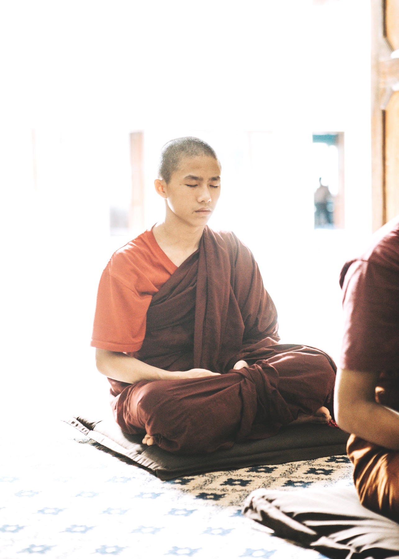 A young monastic seated in meditation